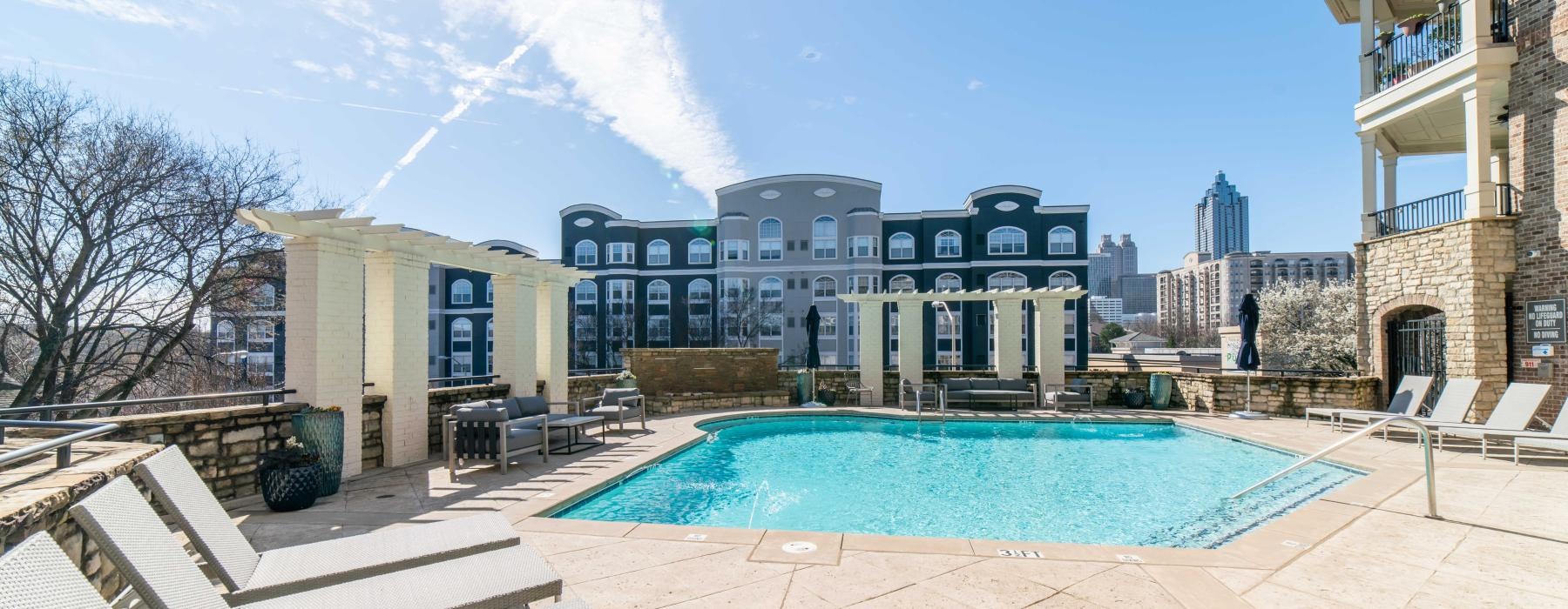 a pool in a courtyard with buildings in the background